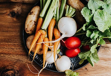 Verduras, como zanahorias, papas y nabos, sobre un plato, para cocinar al vapor.