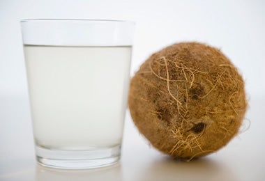 Agua de coco con la fruta a su lado.