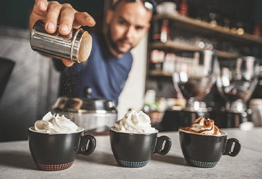 Tres bebidas diferentes con crema batida como decoración.