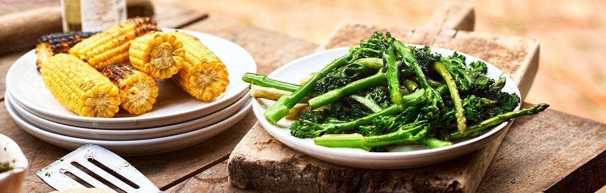 Choclos y espárragos sobre una mesa de madera en una parrillada vegetariana