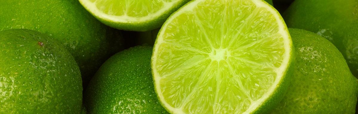 Un limón, uno de los cítricos más usados, partido por la mitad, encima de más limones.