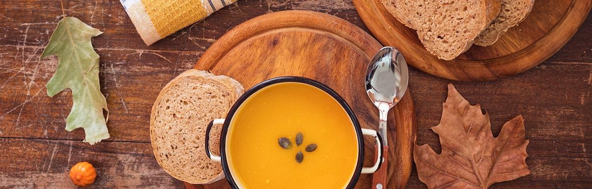 Una de las mejores recetas con zapallo es una crema, acompañada con pan.