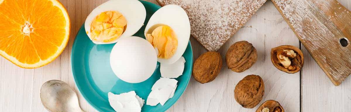 Huevos cocidos, acompañados por jugo de naranja y un croissant.