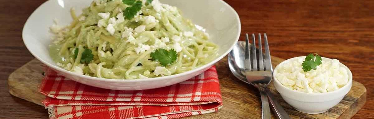 Pasta aromatizada con cilantro, servida en un plato blanco.