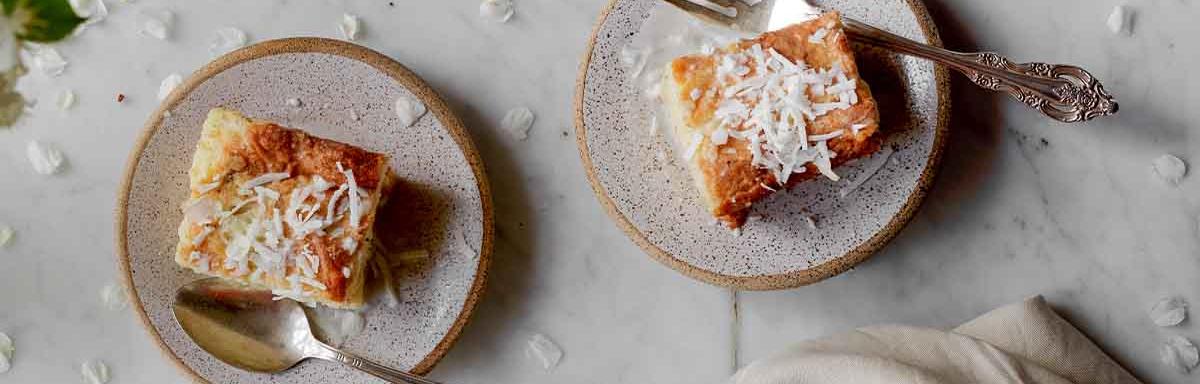 Dos porciones de un pastel sencillo con ralladura de coco.