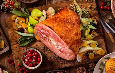 Un jamón de pavo acompañado de diferentes guarniciones navideñas.