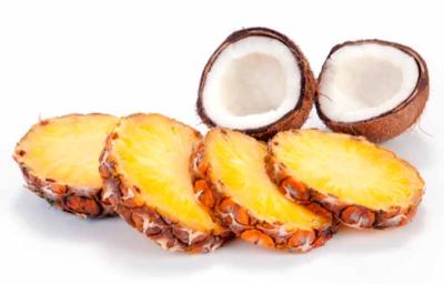 Tajadas de piña y un coco partido por la mitad, dos frutas tropicales.