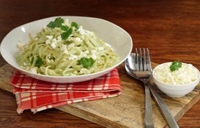 Pasta aromatizada con cilantro, servida en un plato blanco.