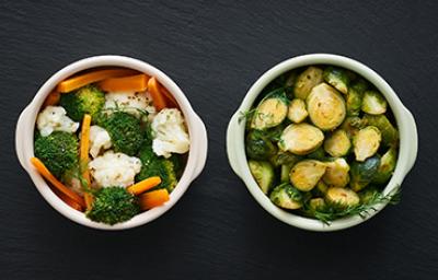 Zanahoria, brócoli y otras verduras que se suelen cocinar al vapor, servidas en dos tazas.